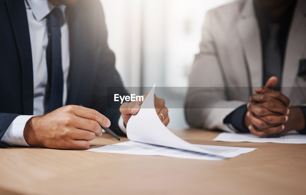 midsection of businessman and colleague working at office