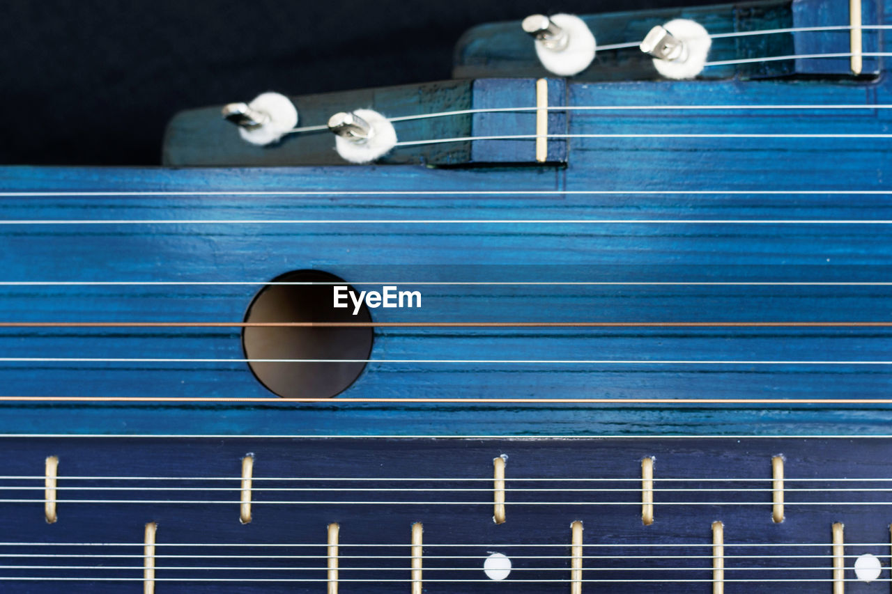 CLOSE-UP OF PIANO KEYS ON BLUE TABLE