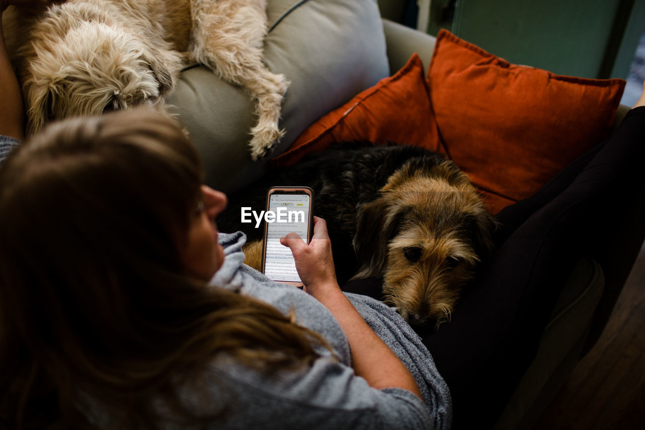 Mid 40's woman sitting on chair with her two large dogs