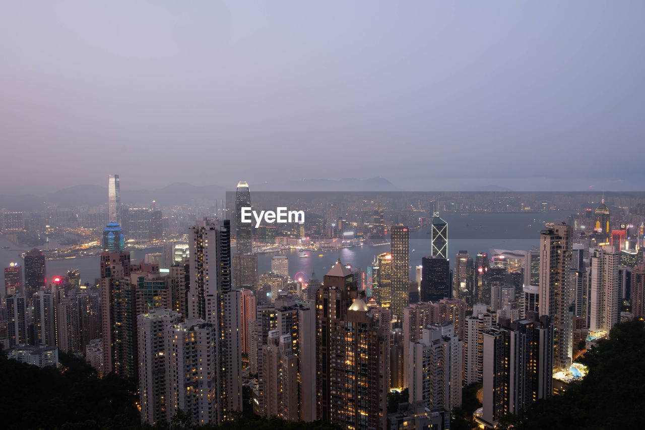 Illuminated buildings in city against sky