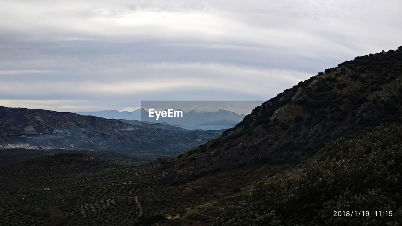 SCENIC VIEW OF MOUNTAIN RANGE AGAINST CLOUDY SKY
