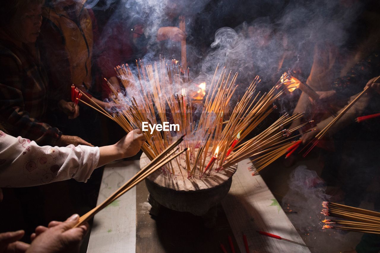 People burning incense sticks at temple