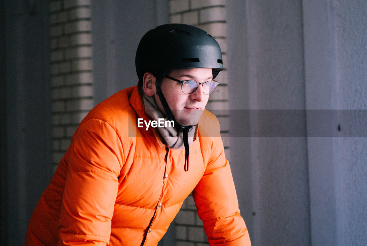 Mature man in warm clothing wearing cycling helmet while looking away