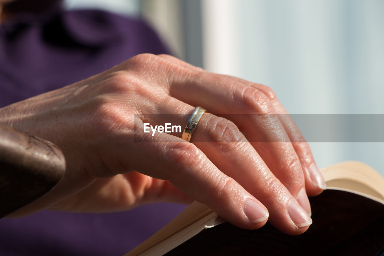 Close-up of man wearing ring at home