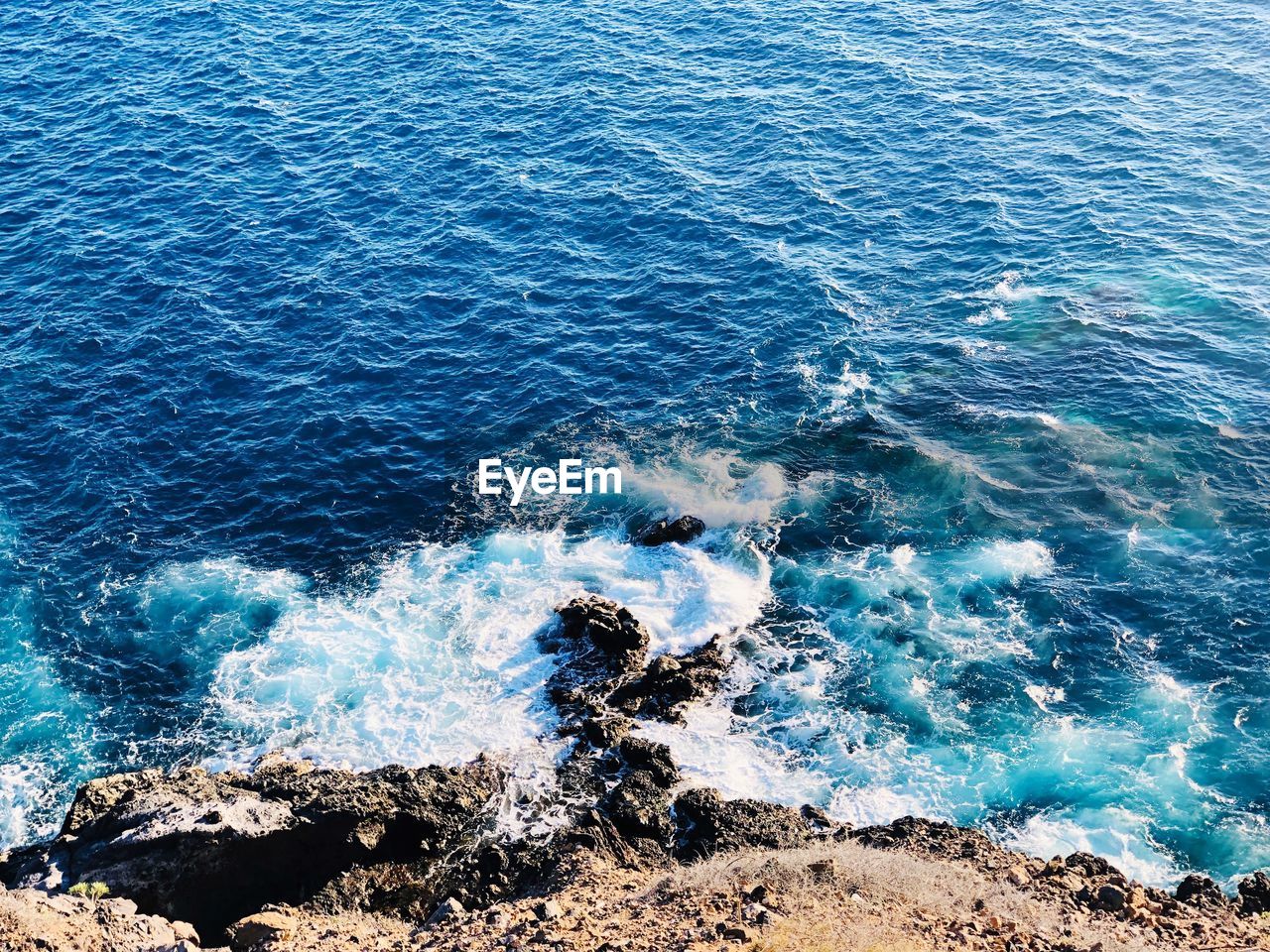 HIGH ANGLE VIEW OF WAVE ON ROCK