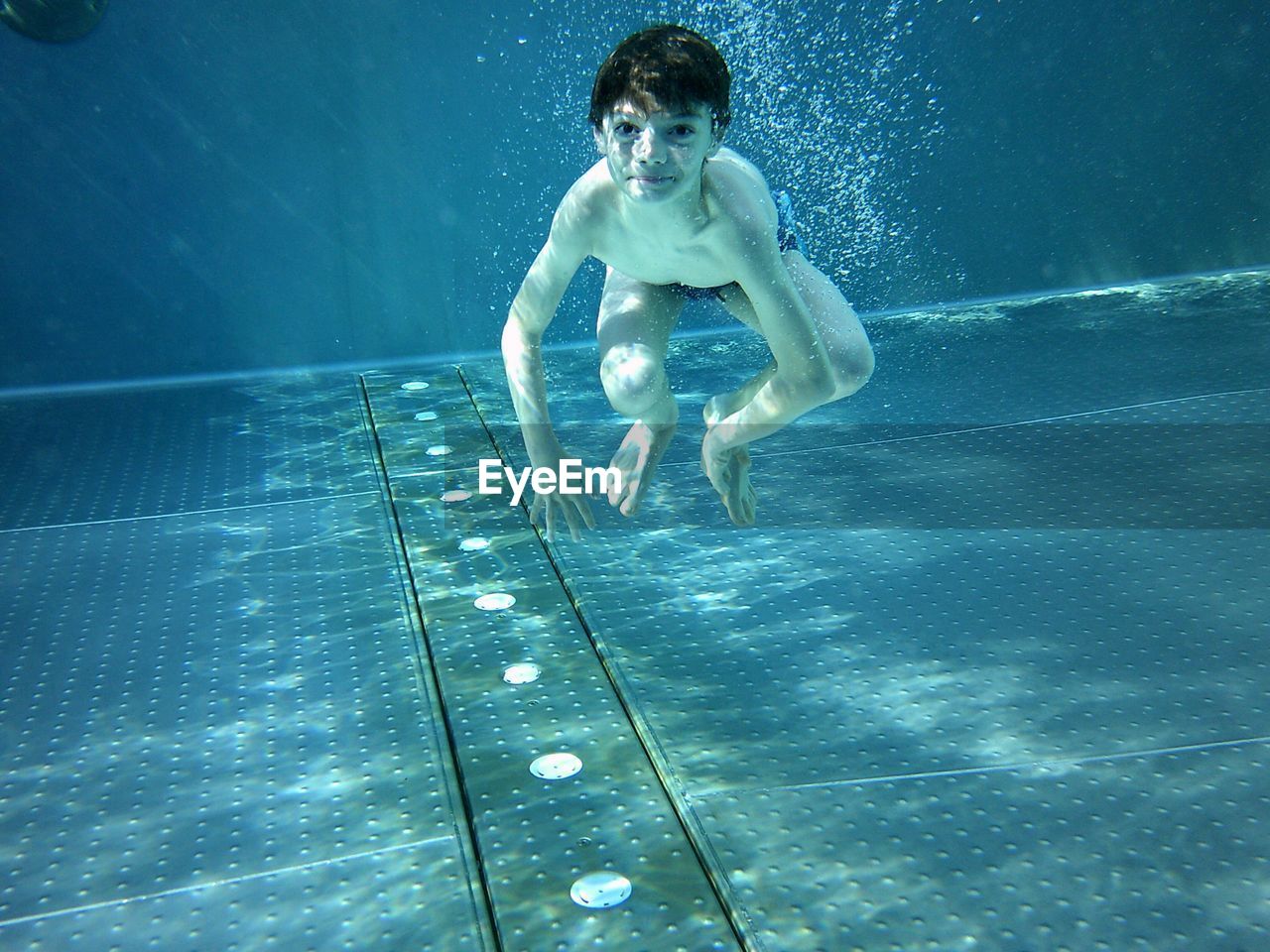 Portrait of shirtless boy swimming in pool