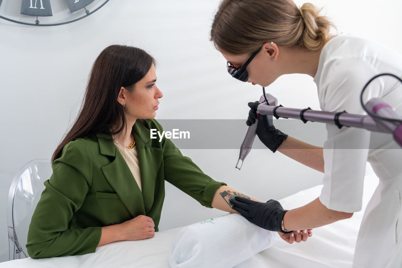 side view of female doctor examining patient in clinic