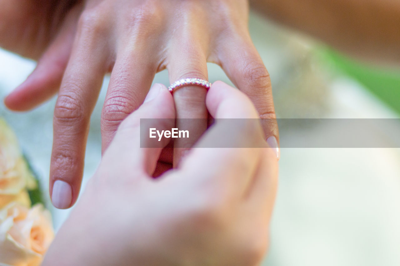 CLOSE-UP OF COUPLE HANDS WITH BABY
