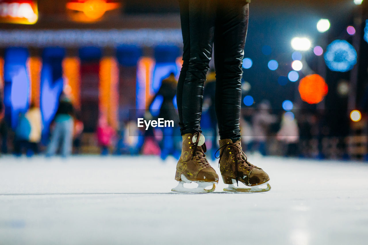 Low section of person ice-skating at night