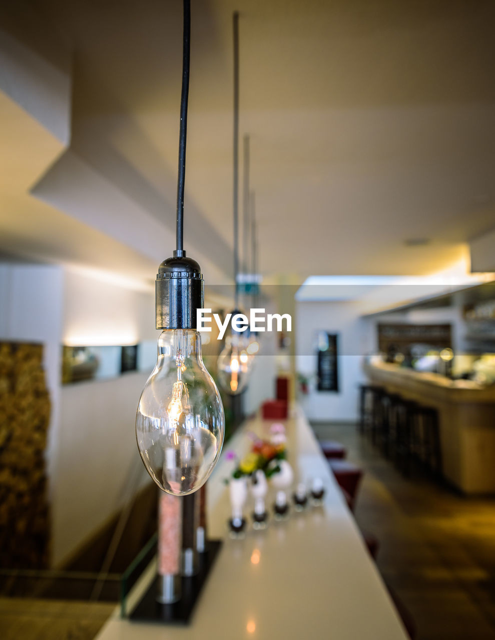 Illuminated light bulbs hanging in restaurant