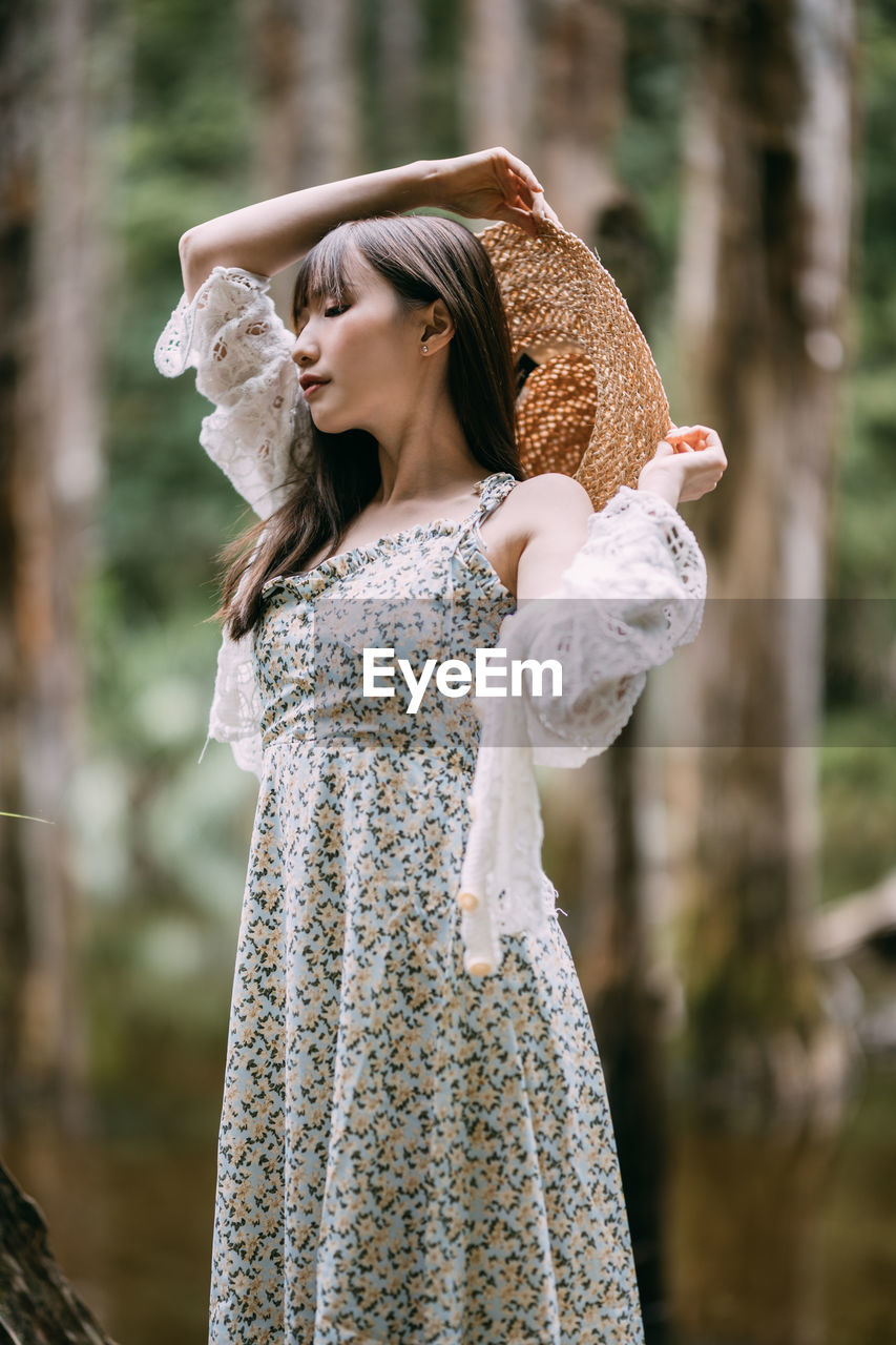 portrait of young woman standing in forest