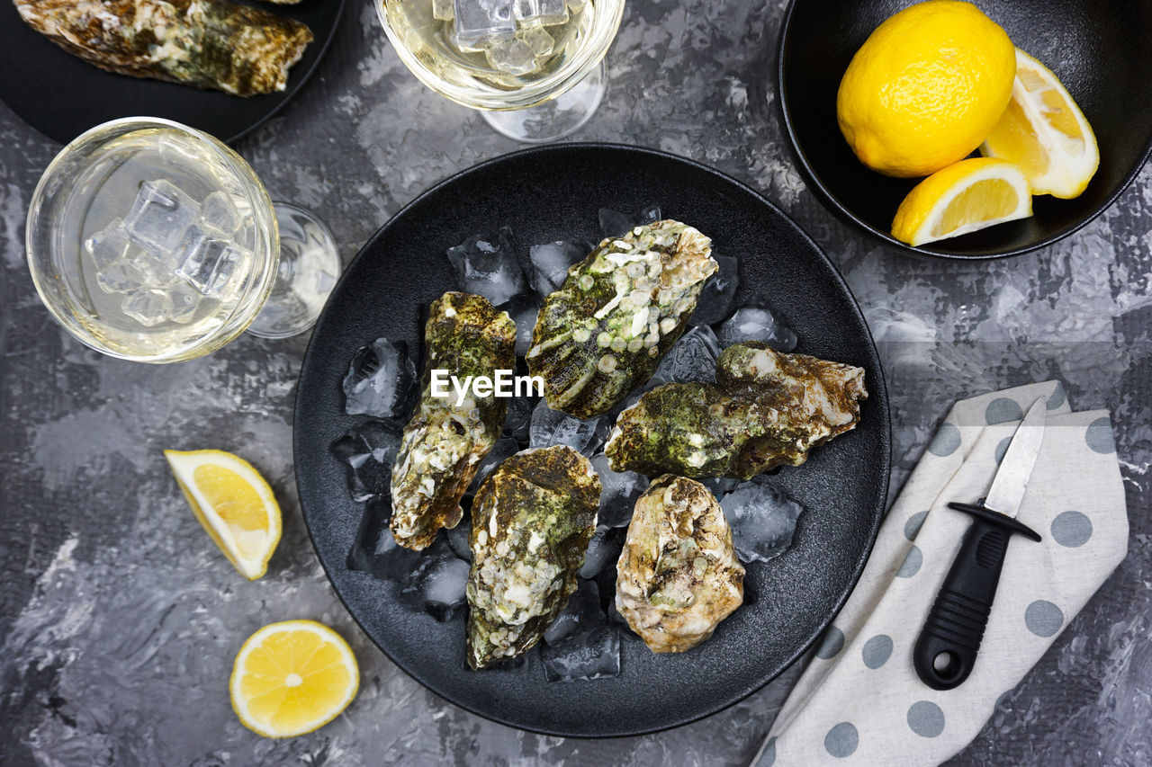 The festive table is served with black dishes with fresh oysters