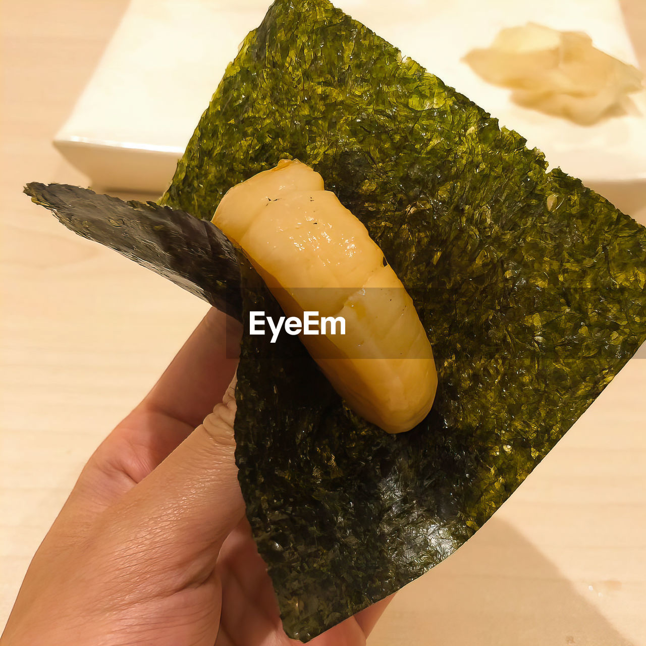 Close-up of hand holding uni sushi ,japan food