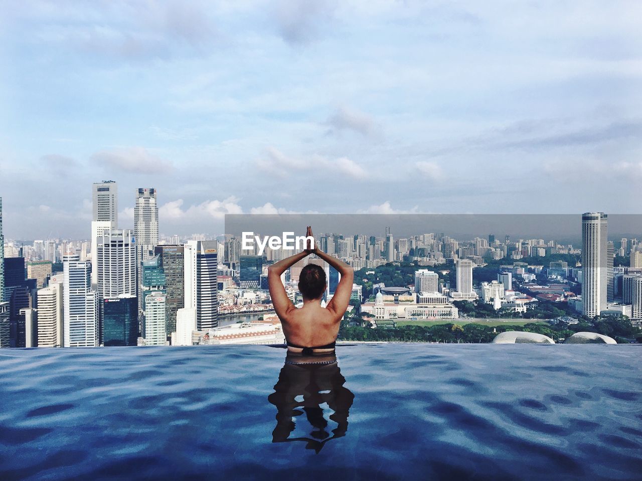 Full length of shirtless man with cityscape against sky