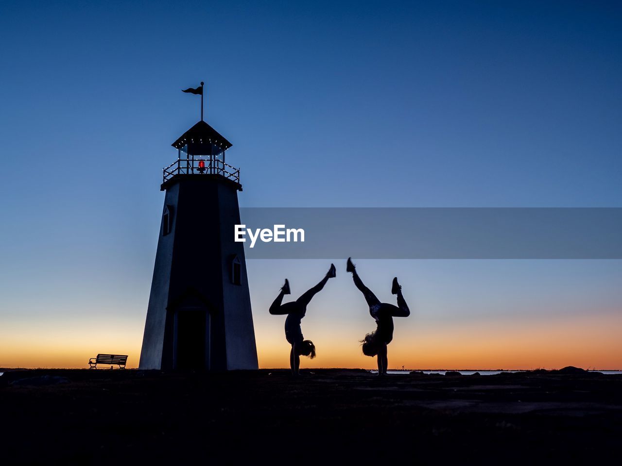 SILHOUETTE SCULPTURE ON SEA SHORE AGAINST CLEAR SKY