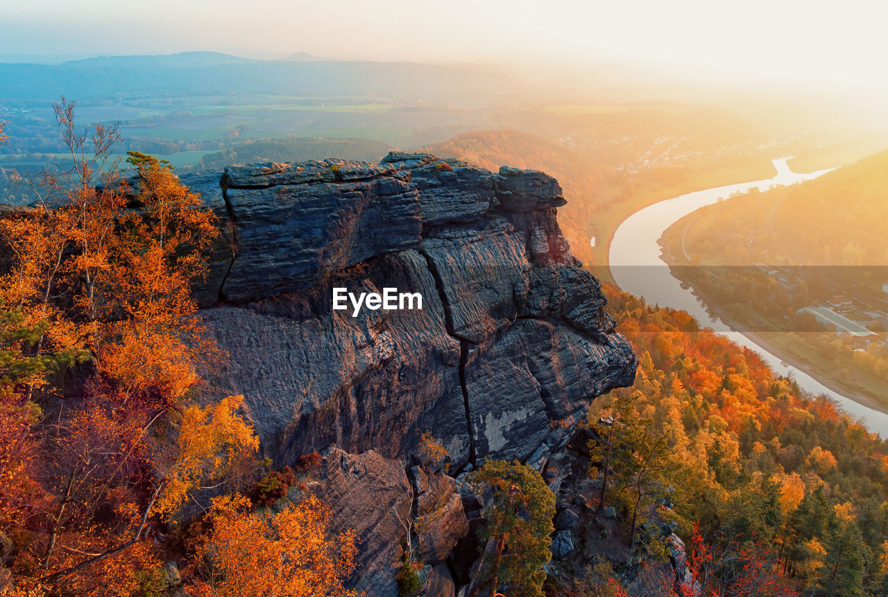 Scenic view of rocky mountain and autumn trees during sunset at saxon switzerland national park
