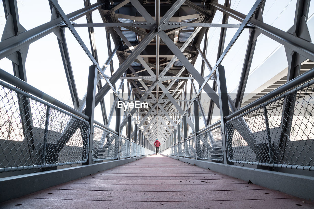 Rear view of person walking on footbridge