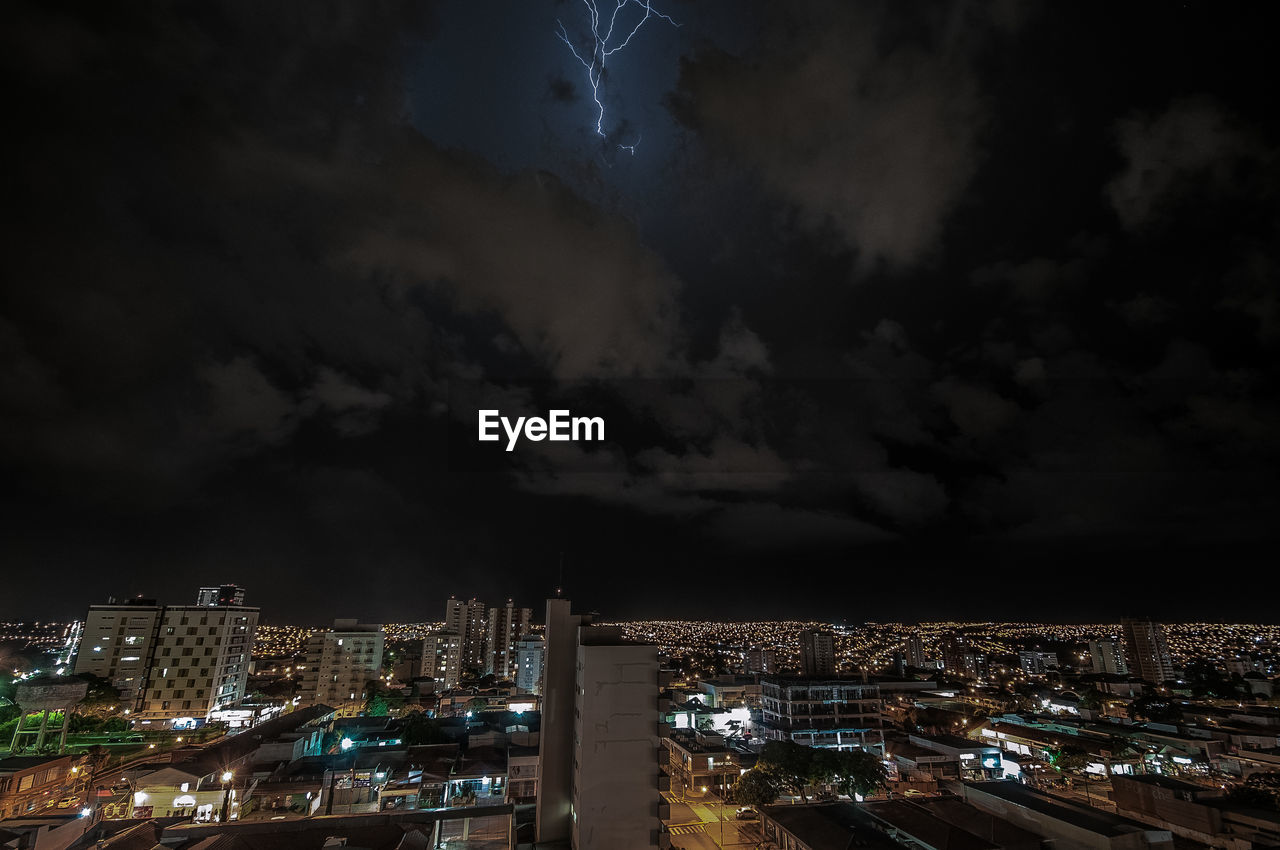 HIGH ANGLE VIEW OF ILLUMINATED CITY BUILDINGS AGAINST SKY