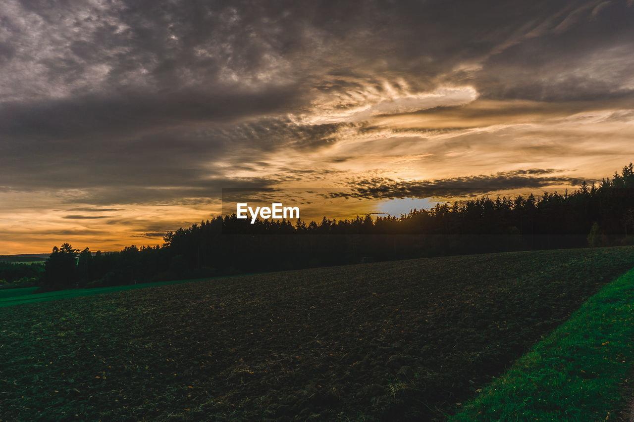 SCENIC VIEW OF AGRICULTURAL FIELD AGAINST SKY AT SUNSET