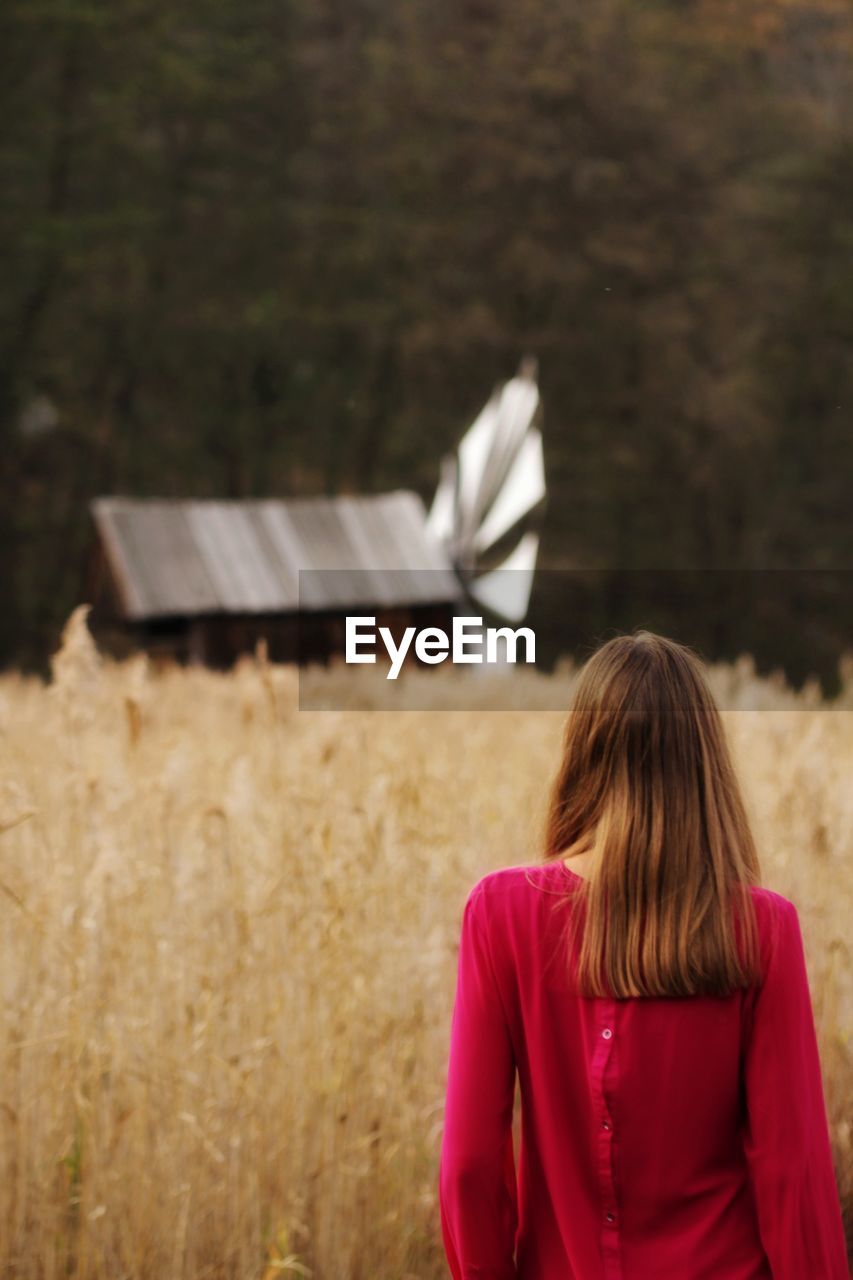 Rear view of woman standing on field