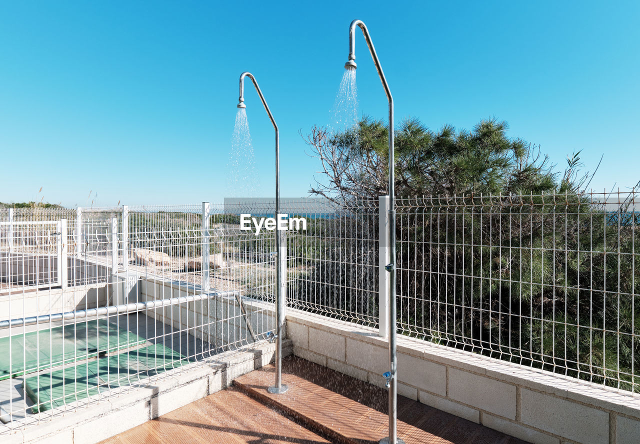 METALLIC FENCE AGAINST BLUE SKY