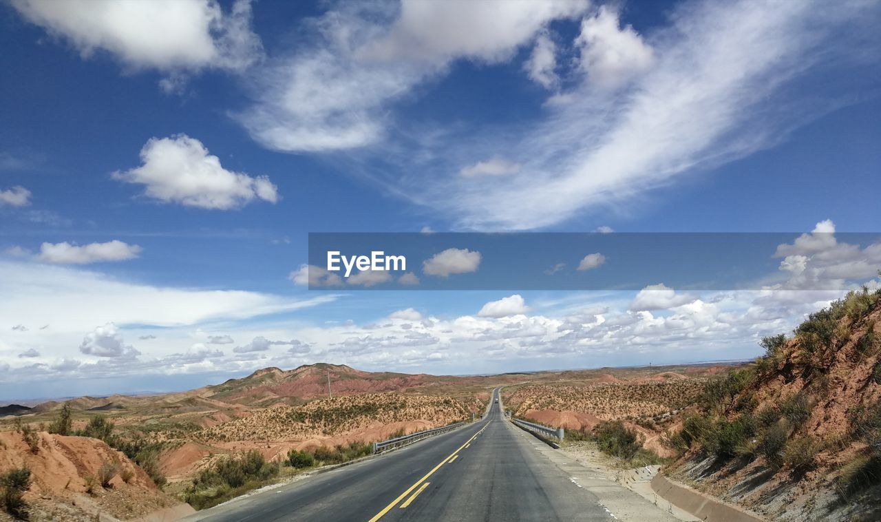 Road trip, open road under blue sky with clouds