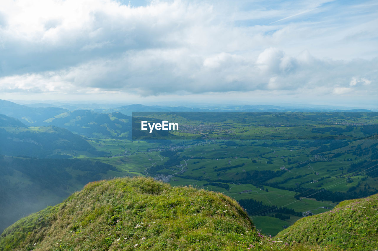 Scenic view of green landscape against sky