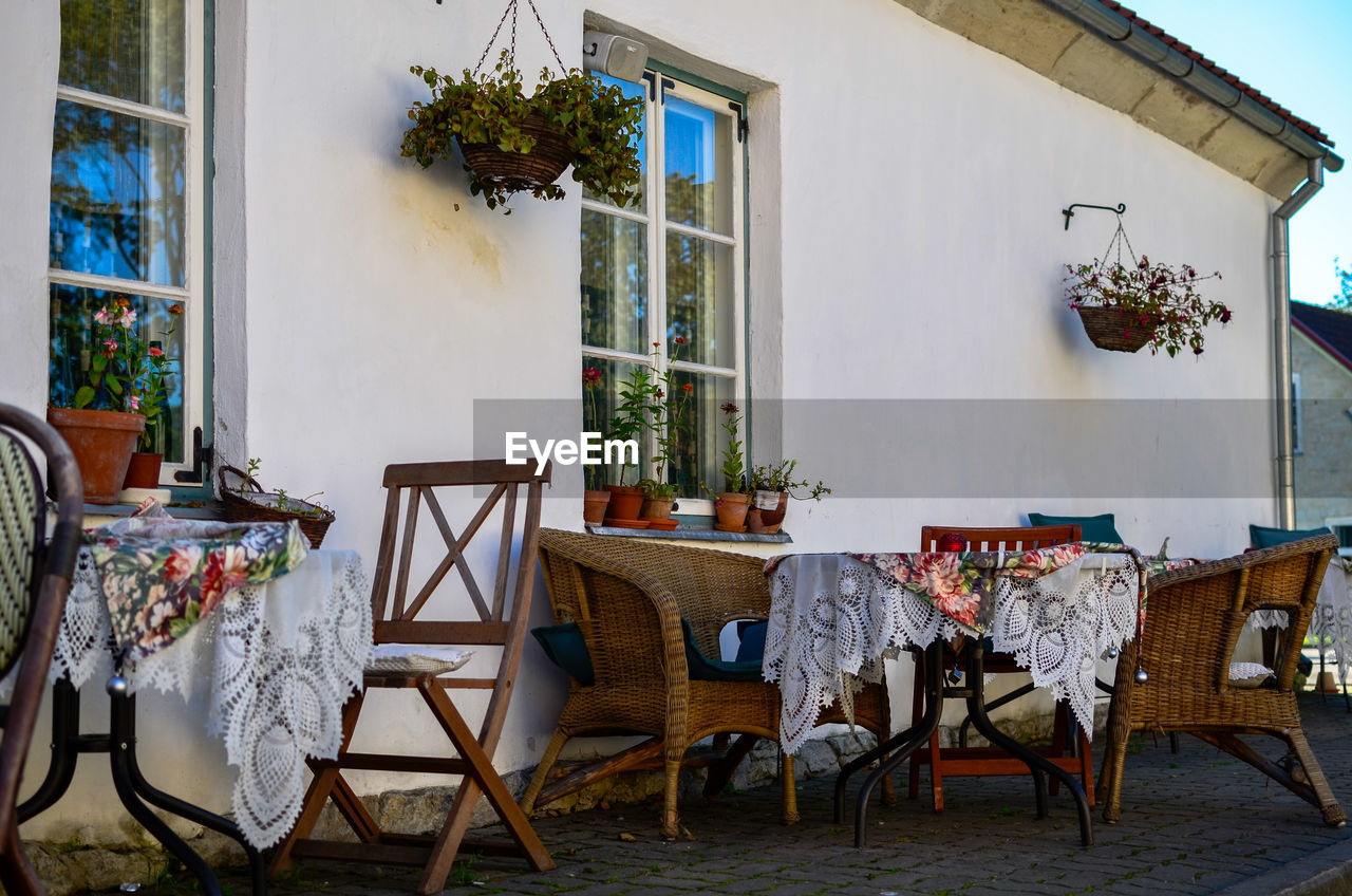 EMPTY CHAIRS AND TABLES AGAINST BUILDINGS