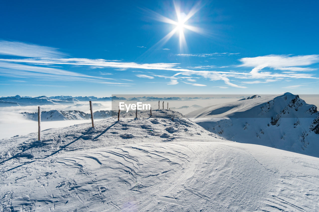 Scenic view of snowcapped mountains against blue sky