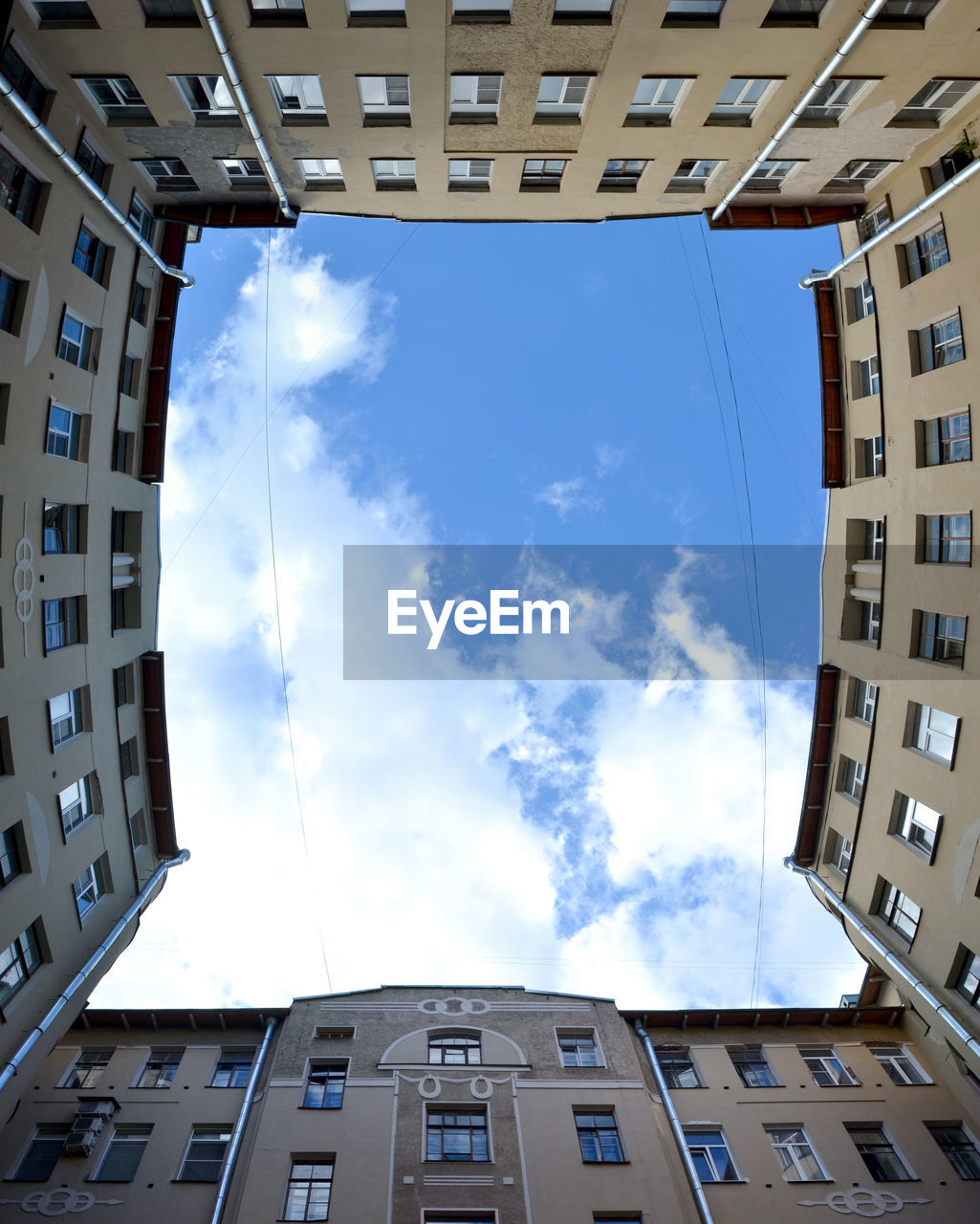 LOW ANGLE VIEW OF BUILDINGS AGAINST CLOUDY SKY