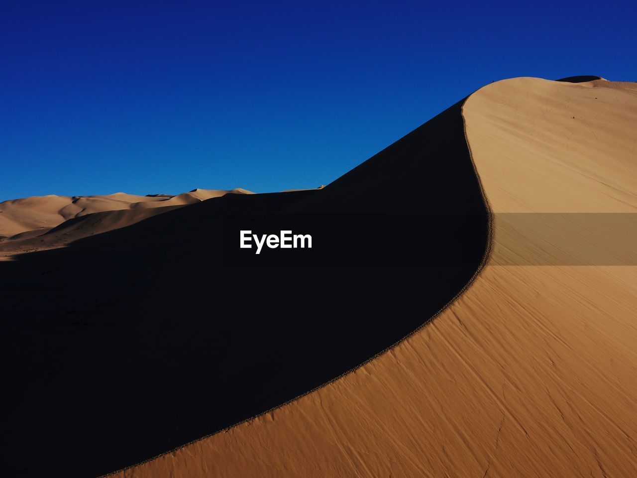 Scenic view of desert against clear blue sky