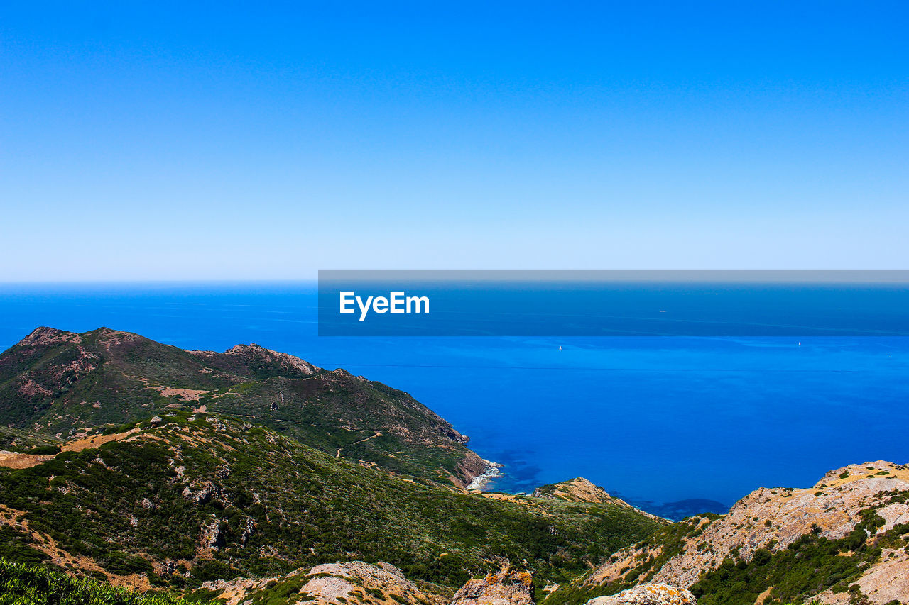 SCENIC VIEW OF SEA AND MOUNTAINS AGAINST CLEAR BLUE SKY