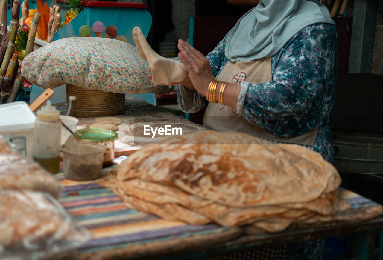 Midsection of woman preparing bread 