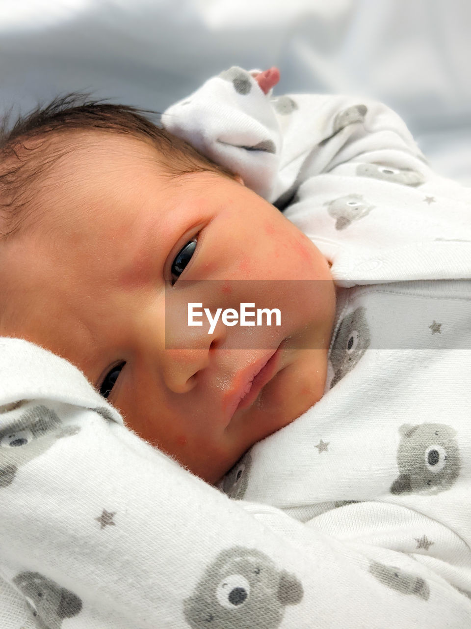 PORTRAIT OF BABY GIRL LYING ON BED