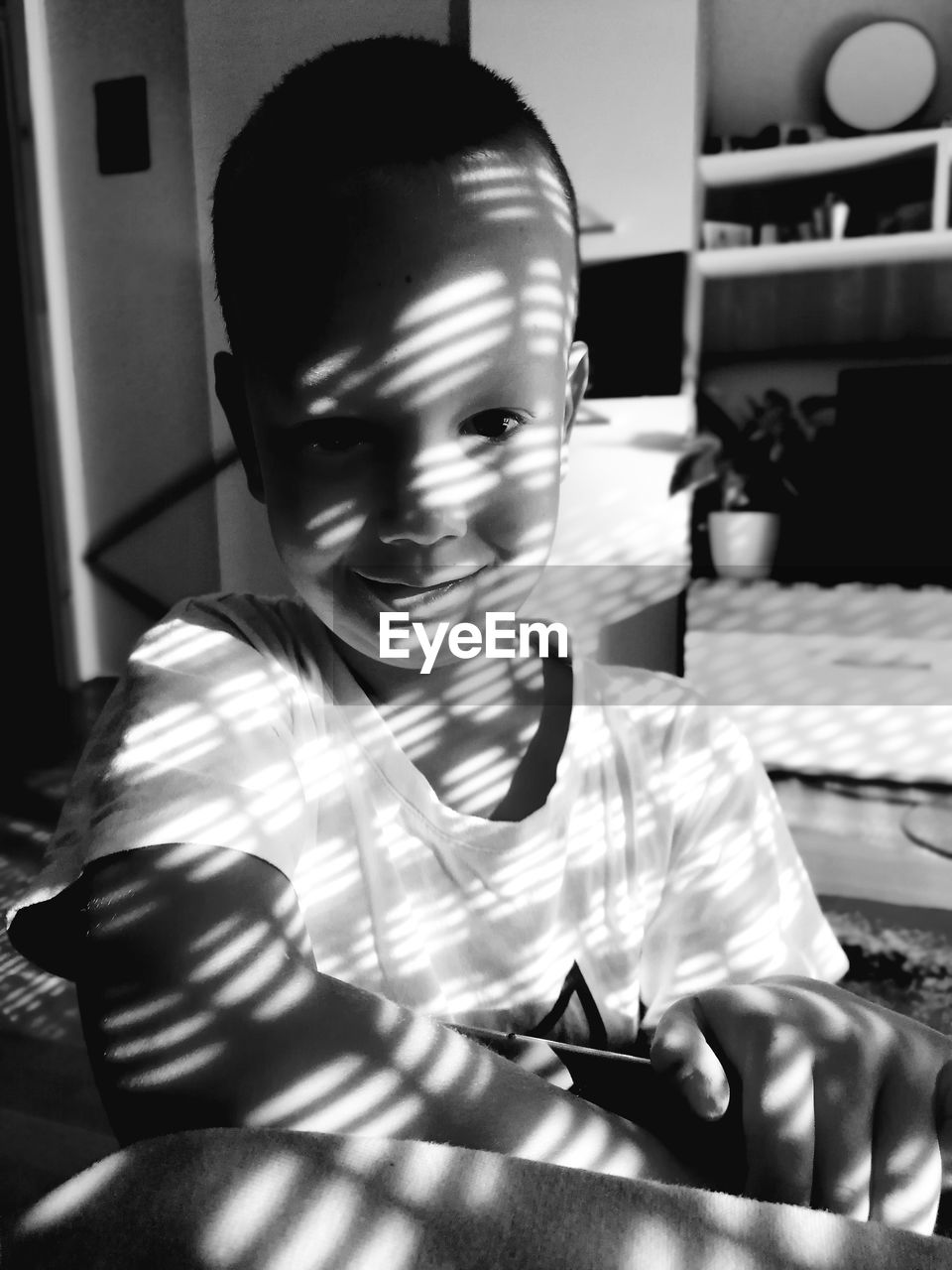 Portrait of boy sitting on table at home
