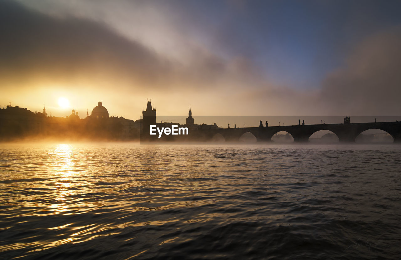 View of bridge over river against cloudy sky