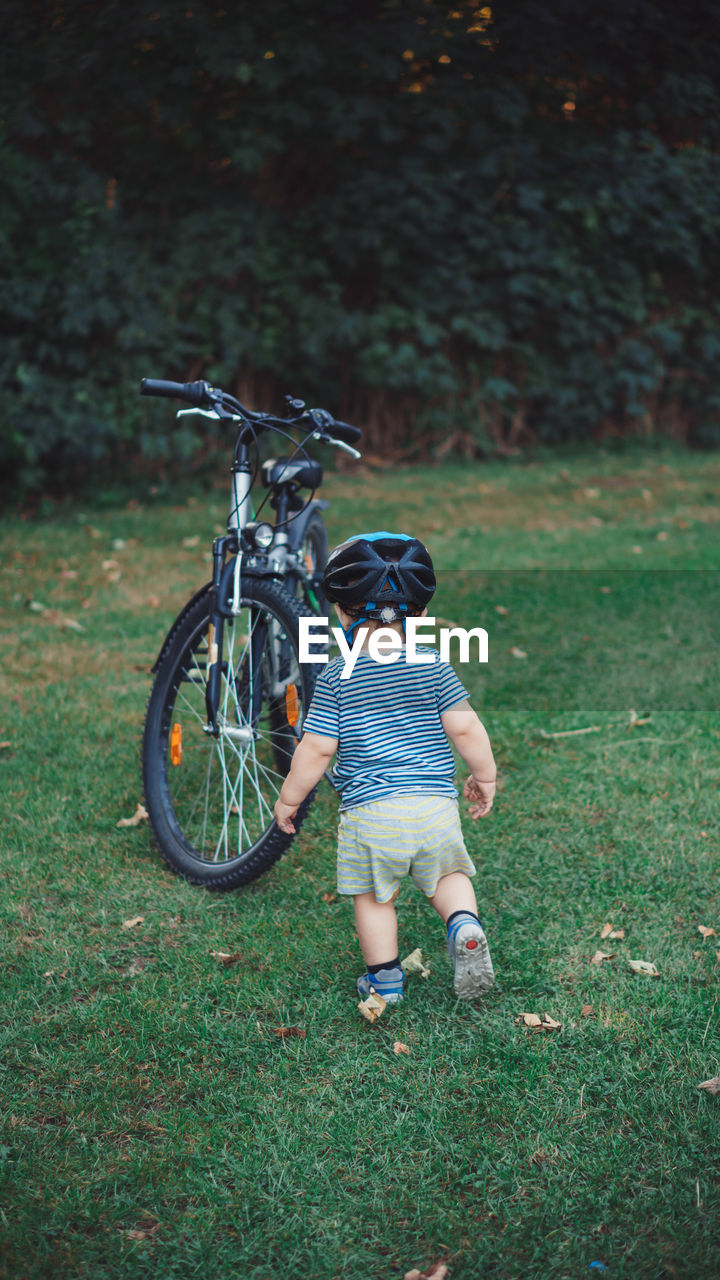 Boy with bicycle on field