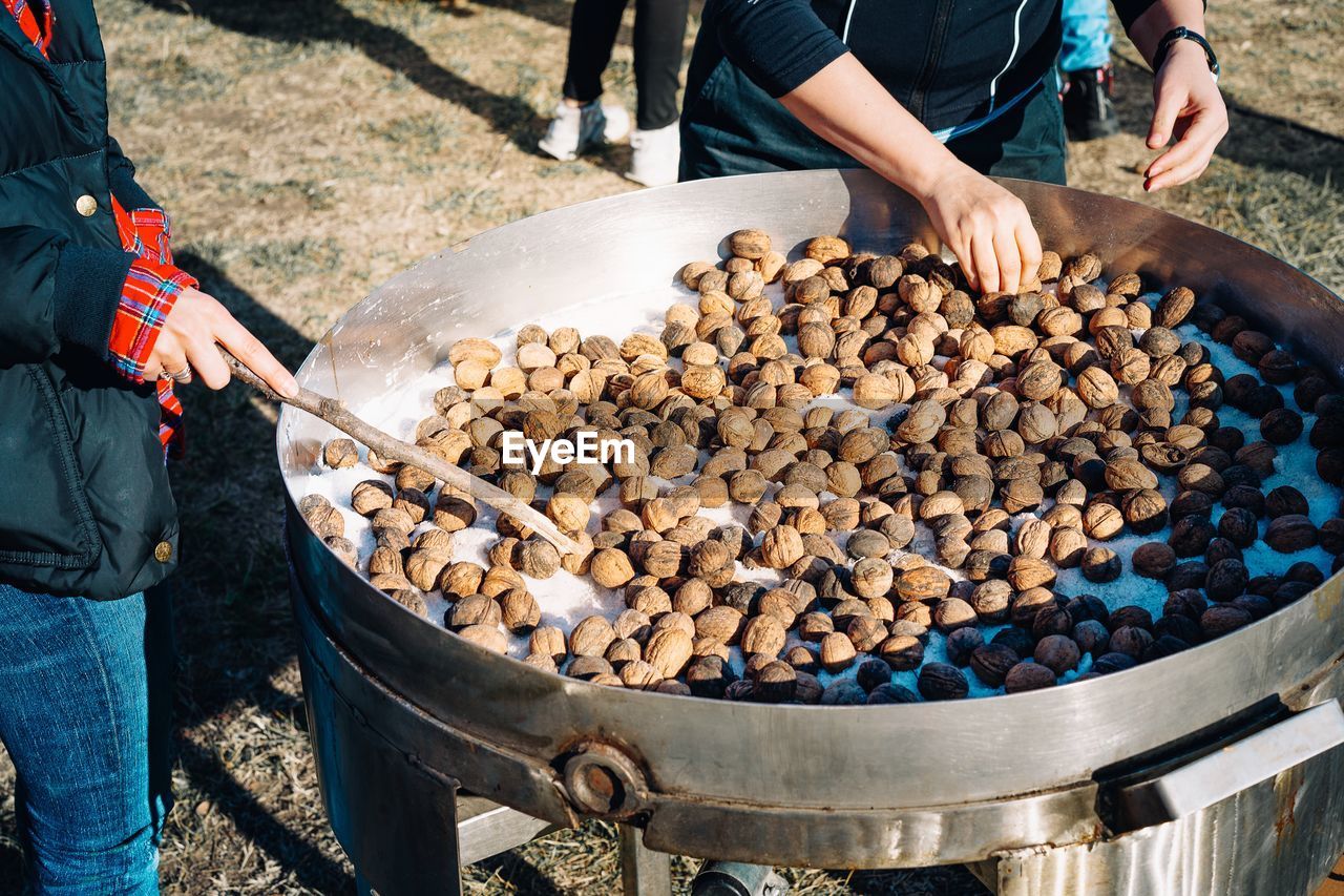 High angle view of people preparing roasted wallnuts at outdoor party