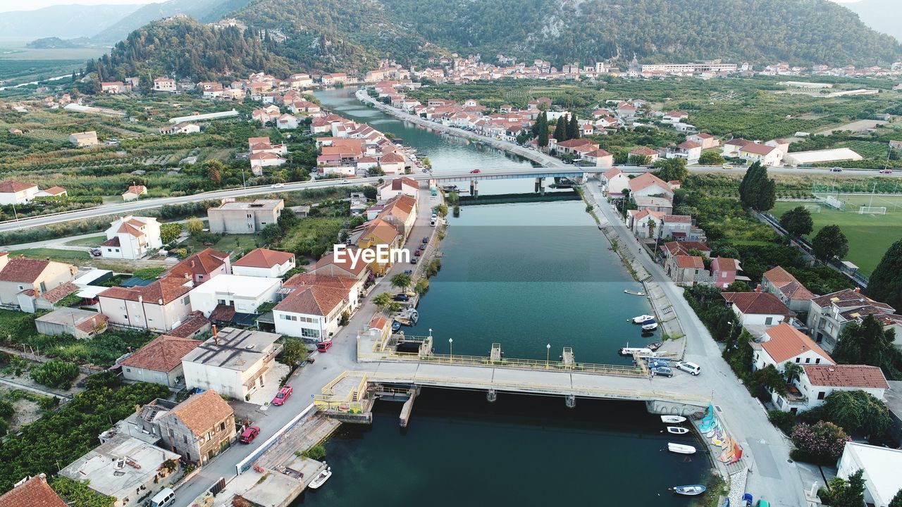 HIGH ANGLE VIEW OF RIVER AMIDST TOWN