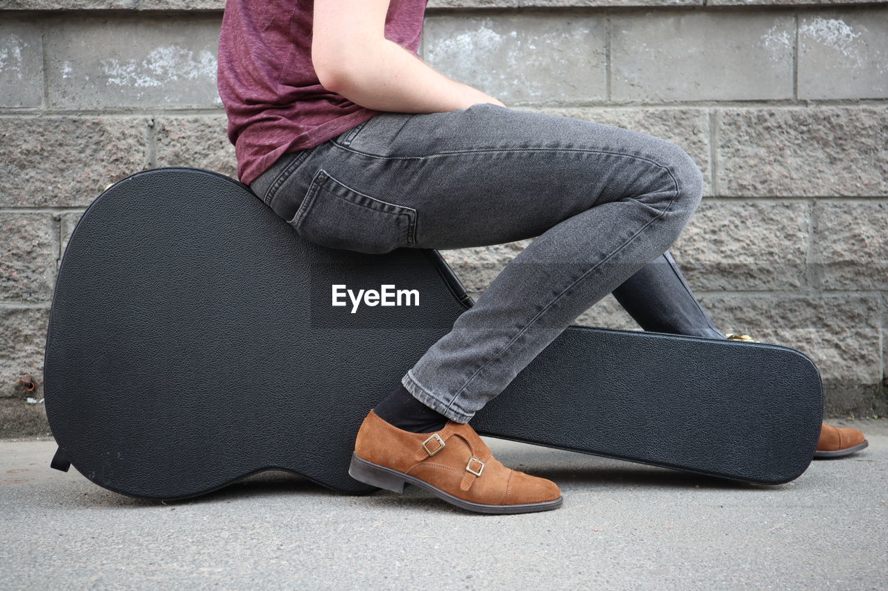 LOW SECTION OF WOMAN SITTING ON SEAT