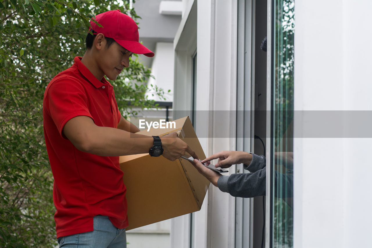 Young man delivering package to customer at doorway