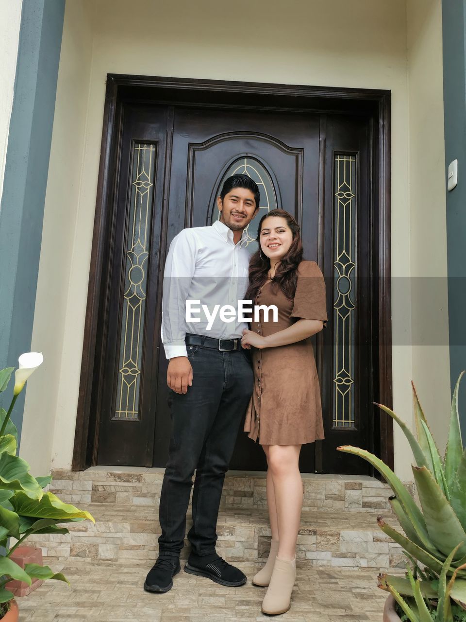 FULL LENGTH PORTRAIT OF WOMAN STANDING AT ENTRANCE OF BUILDING