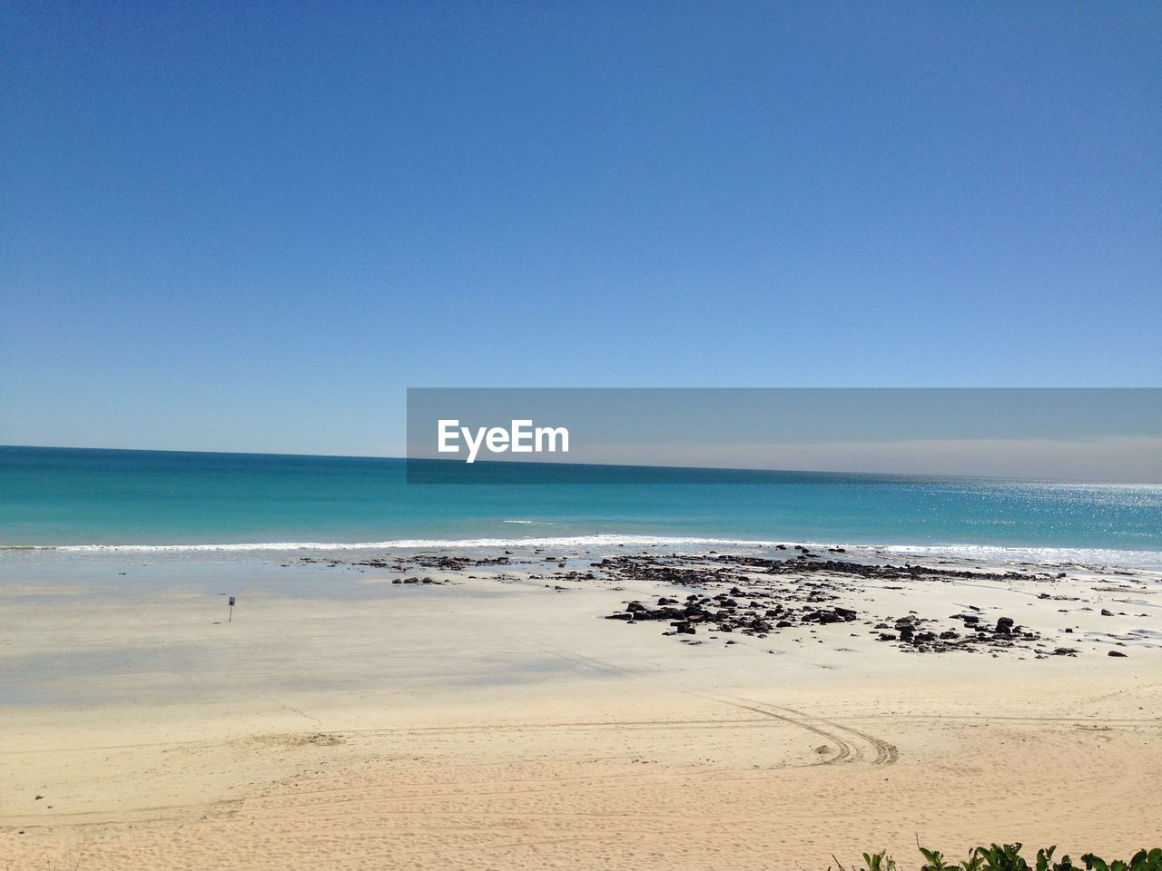 VIEW OF BEACH AGAINST CLEAR BLUE SKY