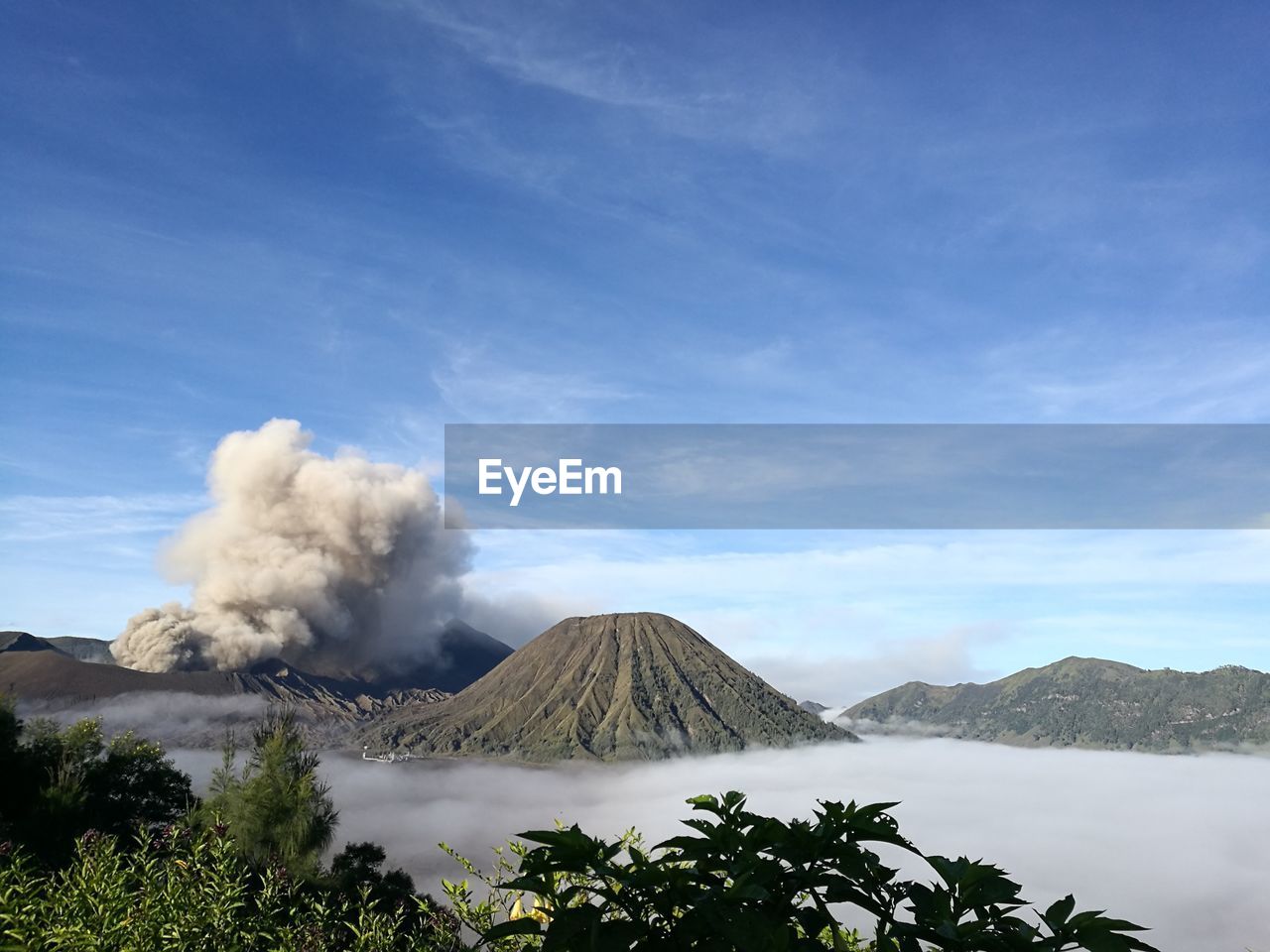 Scenic view of volcano in the fog against cloudy sky