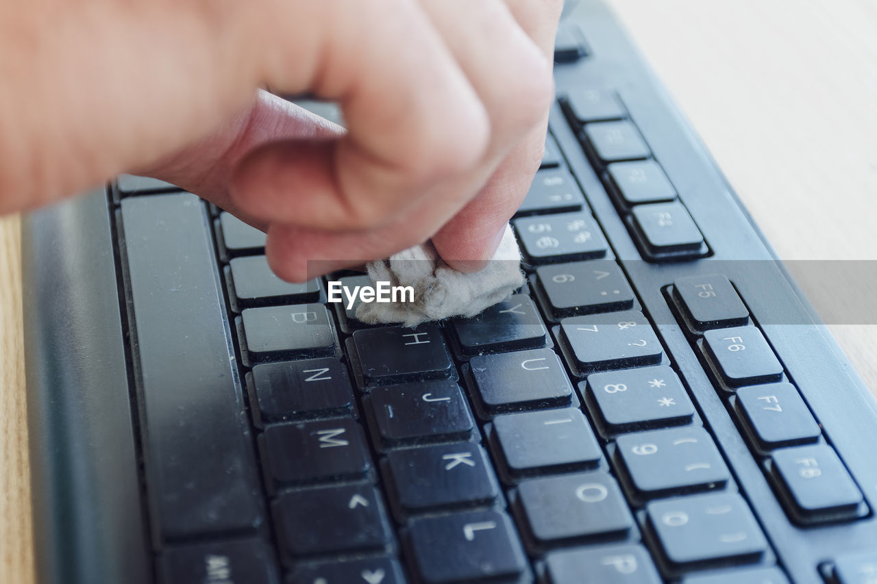 CROPPED IMAGE OF PERSON USING LAPTOP