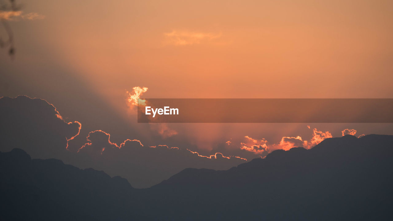 Low angle view of silhouette mountains against sky during sunset