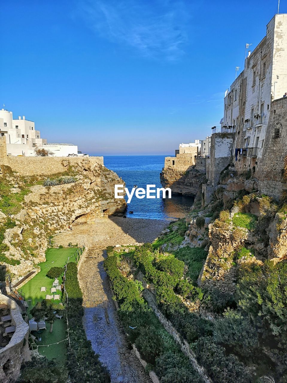 water, architecture, sky, vacation, sea, built structure, history, nature, tourism, building exterior, travel destinations, the past, coast, fortification, cliff, castle, travel, blue, land, town, building, terrain, fort, ruins, scenics - nature, beach, clear sky, day, no people, ancient, old ruin, medieval, city, outdoors, beauty in nature, old, rock, plant, landmark, wall, sunlight, sunny, coastline, horizon over water, bay, holiday, tranquility, fortified wall, horizon, trip