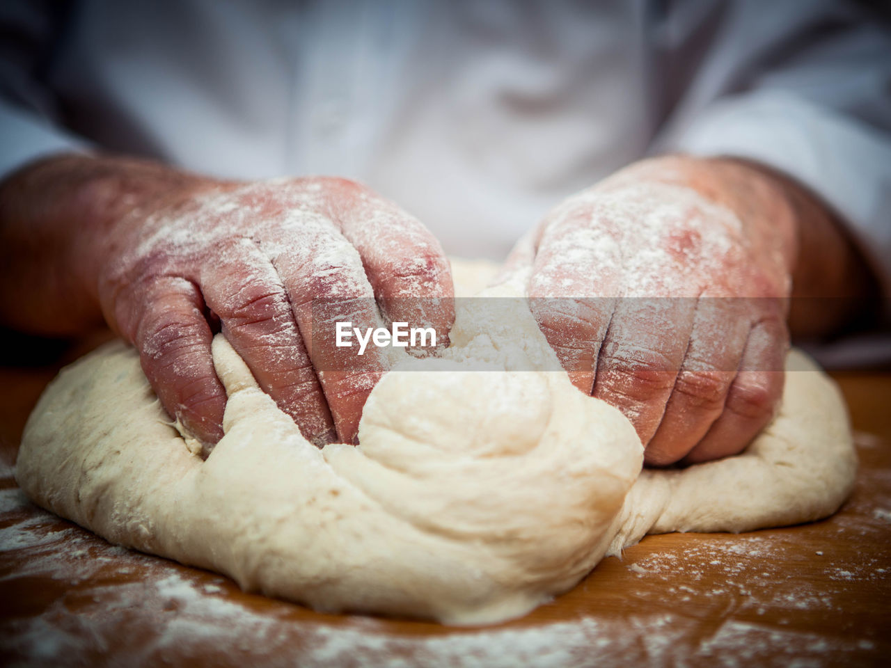 CLOSE-UP OF PERSON PREPARING BREAD