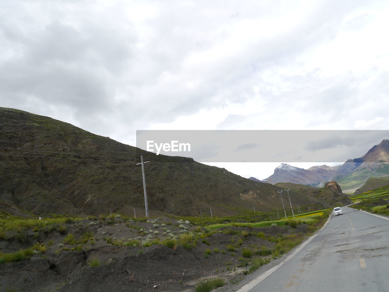 Country road against cloudy sky