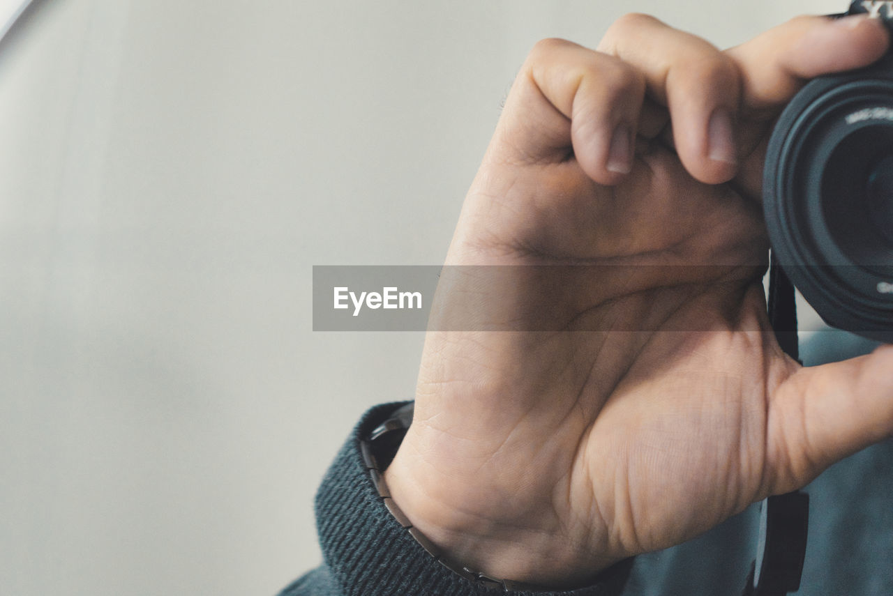 Midsection of man holding camera